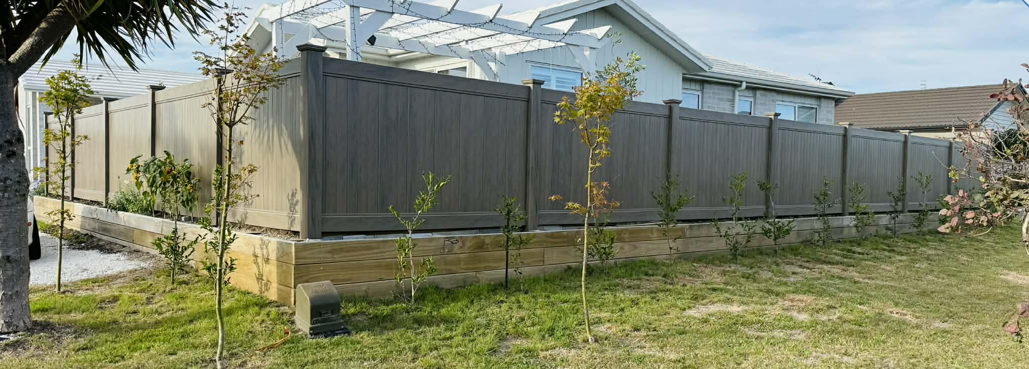 Composite fence with retaining wall